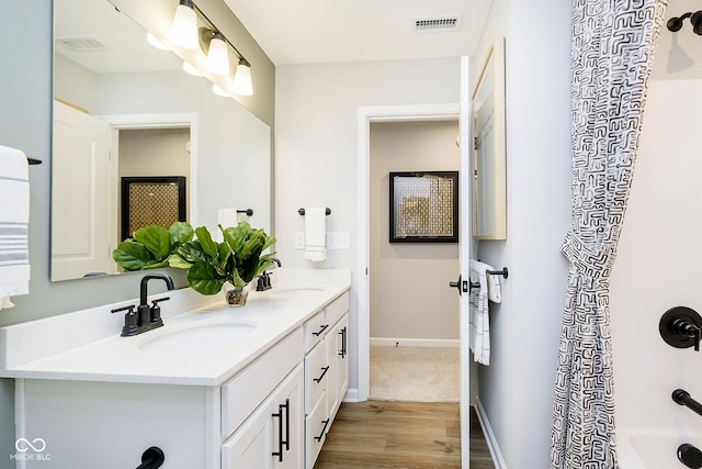 7242 Barrett Dr, Brownsburg, IN 46112 - bathroom featuring double vanity, wood finished floors, baseboards, and shower / tub combo