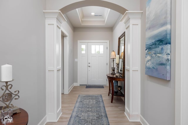 3622 S Setting Sun Ln, New Palestine, IN 46163 - foyer with arched walkways, baseboards, a tray ceiling, light wood-style flooring, and crown molding