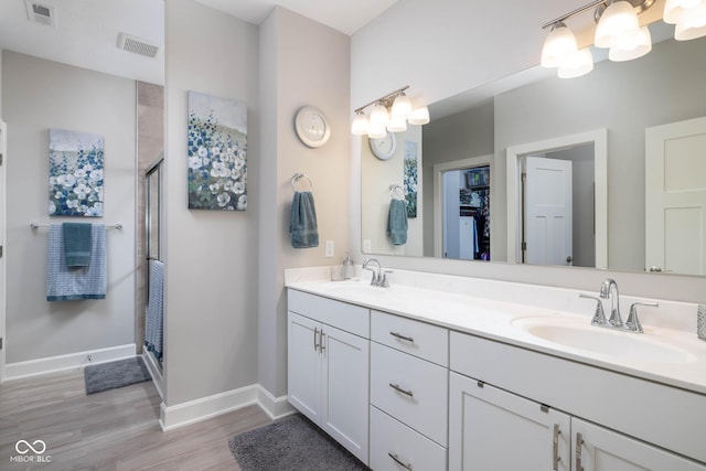 3622 S Setting Sun Ln, New Palestine, IN 46163 - bathroom with wood finished floors, baseboards, a shower stall, double vanity, and a chandelier