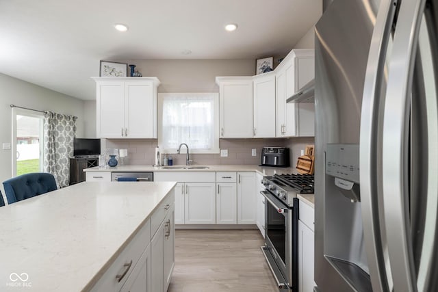 3622 S Setting Sun Ln, New Palestine, IN 46163 - kitchen featuring stainless steel appliances, a sink, backsplash, white cabinetry, and recessed lighting