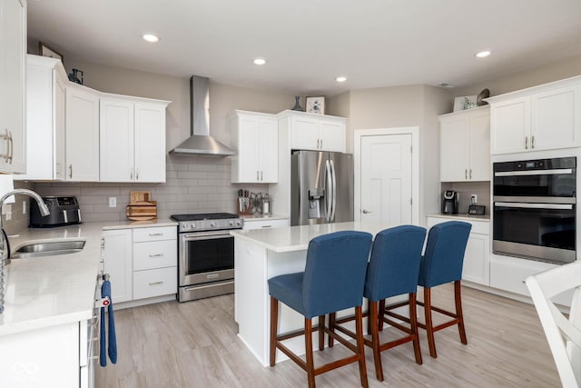 3622 S Setting Sun Ln, New Palestine, IN 46163 - kitchen featuring stainless steel appliances, wall chimney range hood, a sink, a kitchen bar, and backsplash