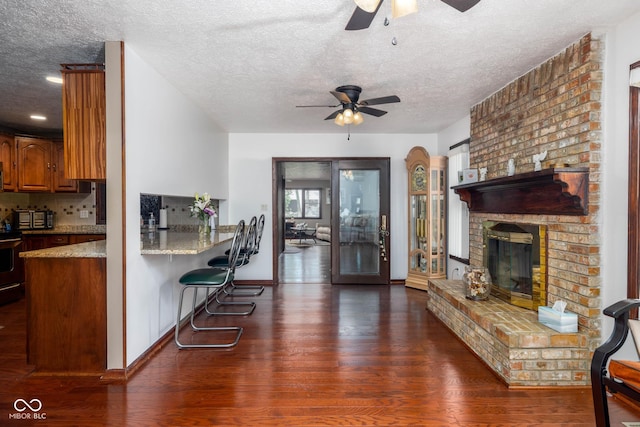 16226 Montrose Ln, Westfield, IN 46074 - living area featuring a ceiling fan, wood finished floors, a textured ceiling, and a fireplace