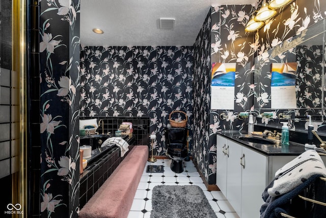 16226 Montrose Ln, Westfield, IN 46074 - bathroom featuring wallpapered walls, tile patterned floors, tiled tub, vanity, and a textured ceiling