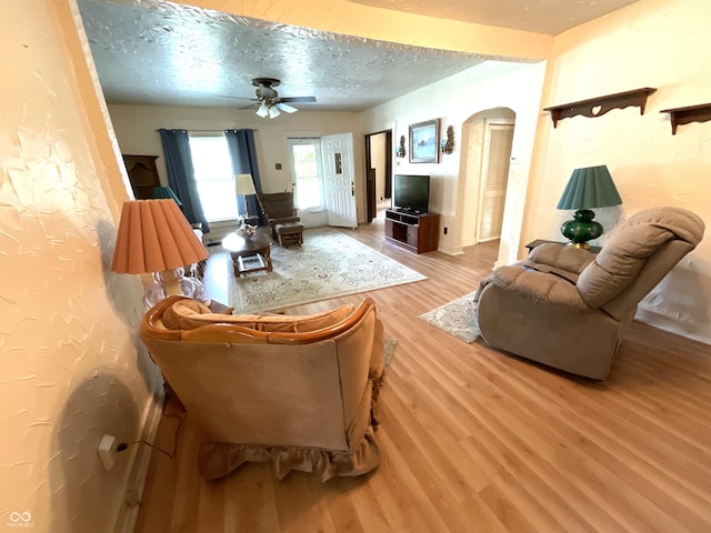 357 S Main St, Spencer, IN 47460 - living area with arched walkways, a textured ceiling, ceiling fan, and light wood-type flooring