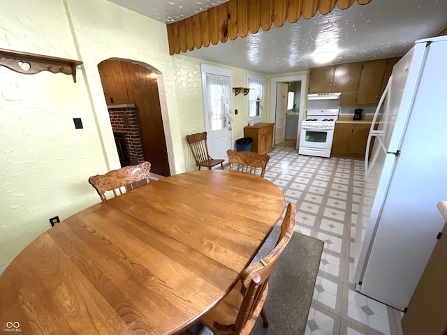 357 S Main St, Spencer, IN 47460 - dining space featuring light floors, a fireplace, arched walkways, and a textured wall