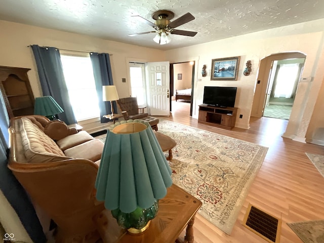 357 S Main St, Spencer, IN 47460 - living area with arched walkways, ceiling fan, light wood-style floors, a textured ceiling, and baseboards