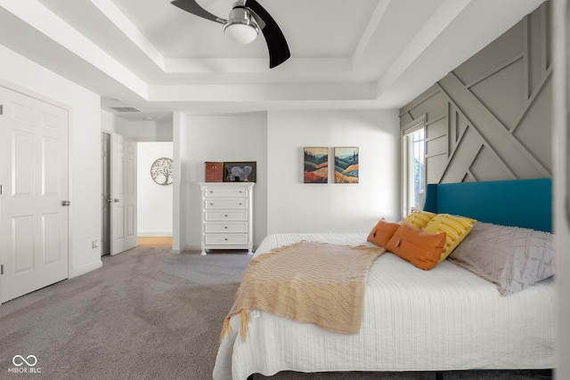 3781 S Station Dr, Columbus, IN 47203 - bedroom featuring a tray ceiling, carpet floors, and a ceiling fan