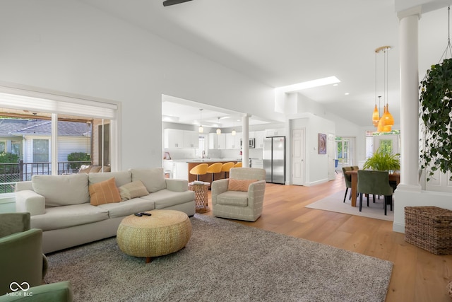 3781 S Station Dr, Columbus, IN 47203 - living area with decorative columns, light wood-style flooring, plenty of natural light, high vaulted ceiling, and ceiling fan