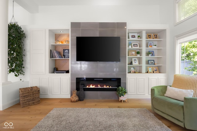3781 S Station Dr, Columbus, IN 47203 - living room featuring a tiled fireplace, light wood finished floors, and built in shelves