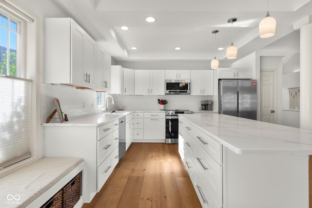 3781 S Station Dr, Columbus, IN 47203 - kitchen with stainless steel appliances, decorative backsplash, a kitchen island, recessed lighting, and light wood-style flooring
