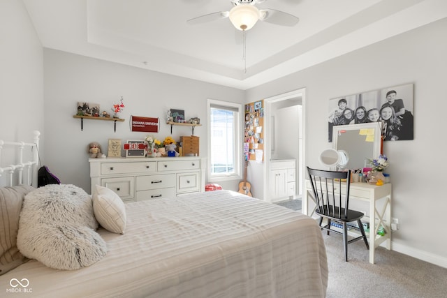 3781 S Station Dr, Columbus, IN 47203 - bedroom featuring a raised ceiling, carpet flooring, baseboards, ensuite bathroom, and a ceiling fan