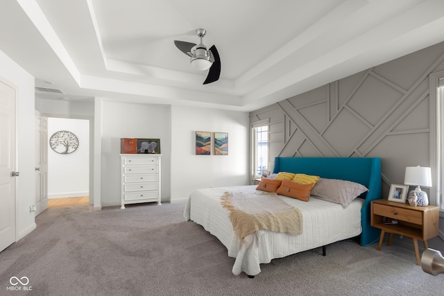 3781 S Station Dr, Columbus, IN 47203 - bedroom featuring a tray ceiling, carpet, ceiling fan, and a decorative wall