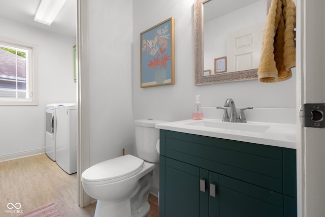 3781 S Station Dr, Columbus, IN 47203 - bathroom featuring washer and clothes dryer, toilet, vanity, wood finished floors, and baseboards