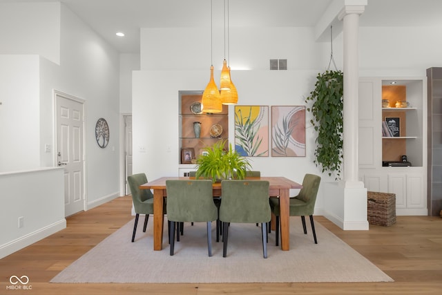 3781 S Station Dr, Columbus, IN 47203 - dining area with wood finished floors, decorative columns, baseboards, recessed lighting, and a towering ceiling
