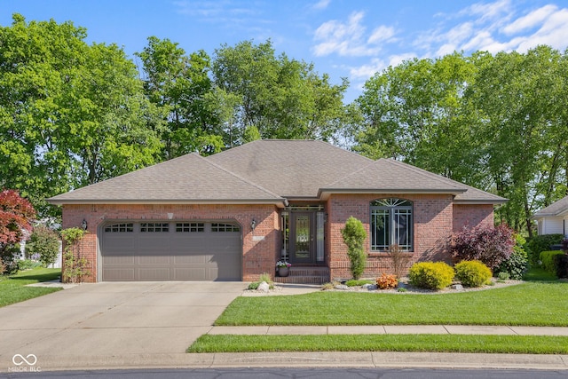 3781 S Station Dr, Columbus, IN 47203 - view of front of property with brick siding, a garage, driveway, a front lawn, and roof with shingles