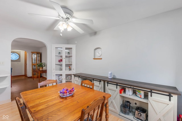 5330 W 56th St, Indianapolis, IN 46254 - dining space featuring arched walkways, ceiling fan, and light wood-type flooring