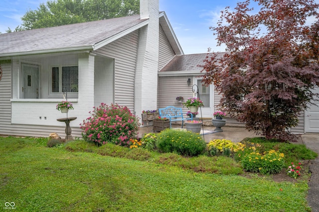 5330 W 56th St, Indianapolis, IN 46254 - view of property exterior featuring a chimney, a shingled roof, a lawn, and brick siding
