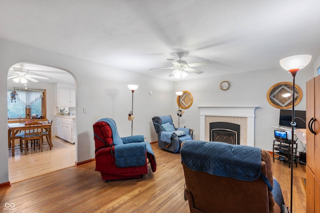5330 W 56th St, Indianapolis, IN 46254 - living room featuring a ceiling fan, light wood finished floors, a fireplace, and arched walkways