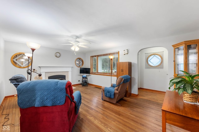 5330 W 56th St, Indianapolis, IN 46254 - living room featuring a ceiling fan, a tile fireplace, and wood-type flooring
