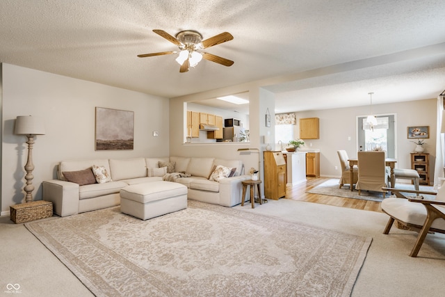 14291 Holly Berry Cir, Fishers, IN 46038 - living room with ceiling fan, light colored carpet, a textured ceiling, and baseboards