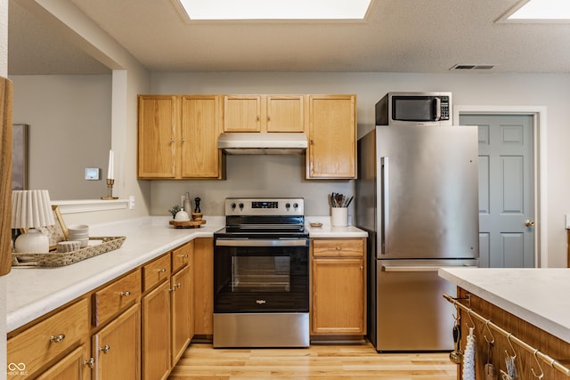14291 Holly Berry Cir, Fishers, IN 46038 - kitchen featuring appliances with stainless steel finishes, under cabinet range hood, light wood-style flooring, and light countertops