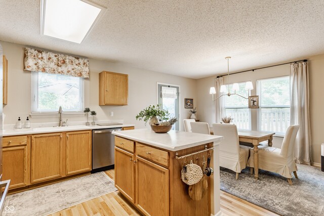14291 Holly Berry Cir, Fishers, IN 46038 - kitchen with a sink, dishwasher, light wood-style floors, a textured ceiling, and a chandelier