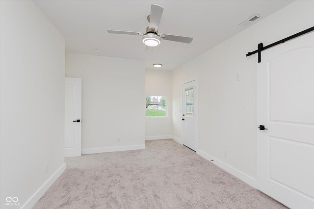 2302 S Pennsylvania St, Indianapolis, IN 46225 - carpeted spare room featuring ceiling fan, a barn door, and baseboards