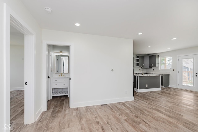 2302 S Pennsylvania St, Indianapolis, IN 46225 - unfurnished living room with a sink, light wood-type flooring, baseboards, and recessed lighting
