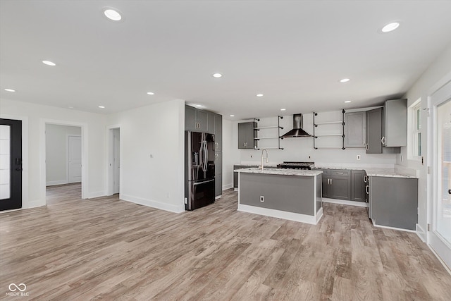 2302 S Pennsylvania St, Indianapolis, IN 46225 - kitchen with fridge with ice dispenser, gray cabinets, open shelves, wall chimney range hood, and light wood finished floors