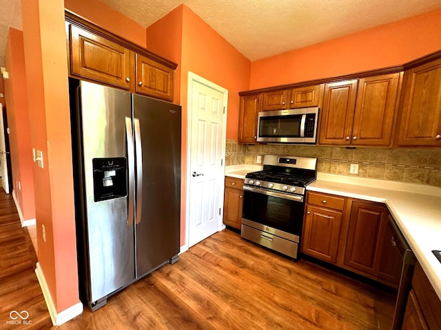 800 Eastfield Dr, Crawfordsville, IN 47933 - kitchen with stainless steel appliances, wood finished floors, tasteful backsplash, light countertops, and brown cabinetry