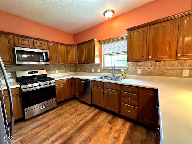 800 Eastfield Dr, Crawfordsville, IN 47933 - kitchen featuring stainless steel appliances, a sink, wood finished floors, light countertops, and a textured ceiling
