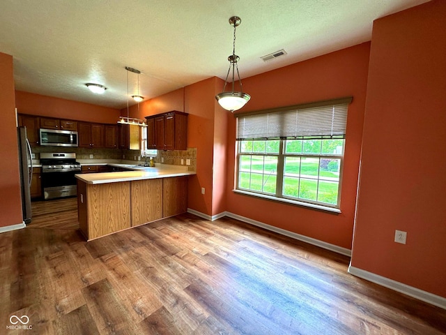 800 Eastfield Dr, Crawfordsville, IN 47933 - kitchen featuring stainless steel appliances, a peninsula, wood finished floors, and light countertops