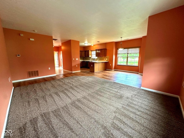 800 Eastfield Dr, Crawfordsville, IN 47933 - unfurnished living room featuring baseboards, light colored carpet, and light wood-style floors