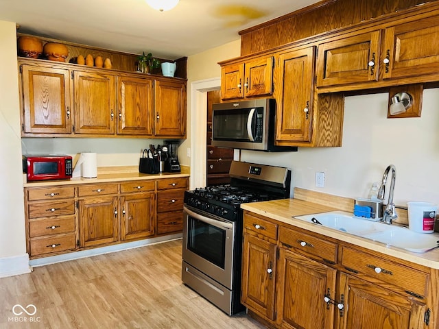 4850 E University Ave, Indianapolis, IN 46201 - kitchen featuring stainless steel appliances, a sink, brown cabinetry, and light countertops