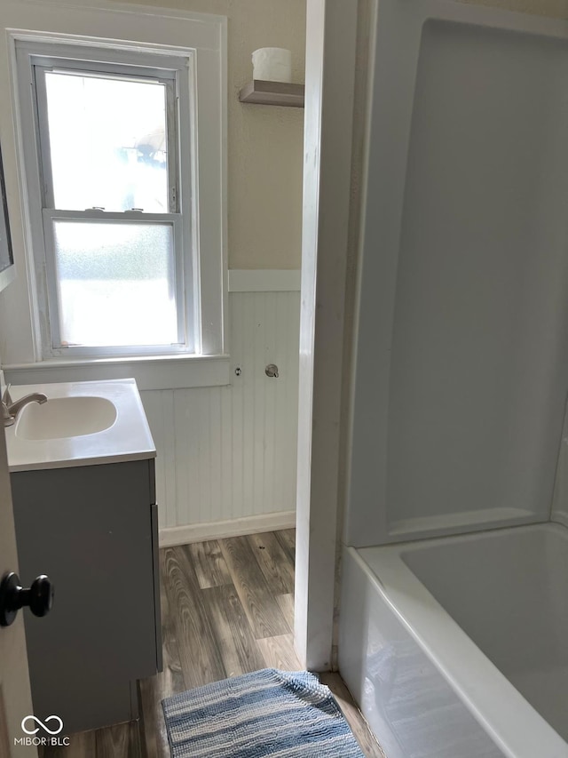 4850 E University Ave, Indianapolis, IN 46201 - full bath featuring a wainscoted wall, vanity, healthy amount of natural light, and wood finished floors