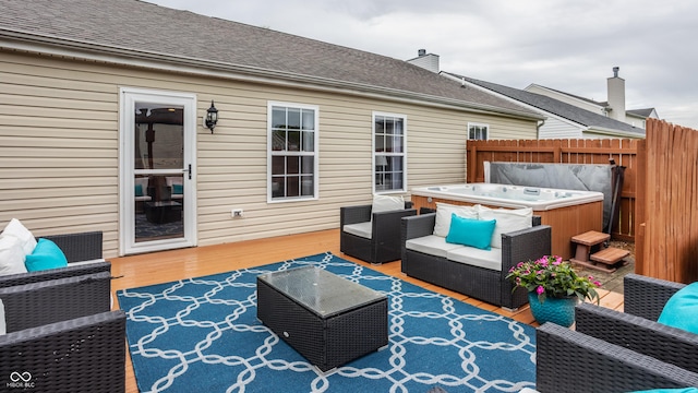 wooden deck with a hot tub, an outdoor living space, and fence