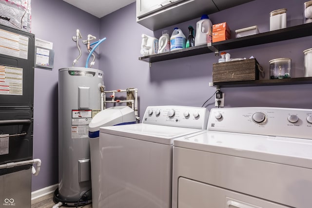 laundry room featuring washing machine and dryer, electric water heater, wood finished floors, heating unit, and baseboards