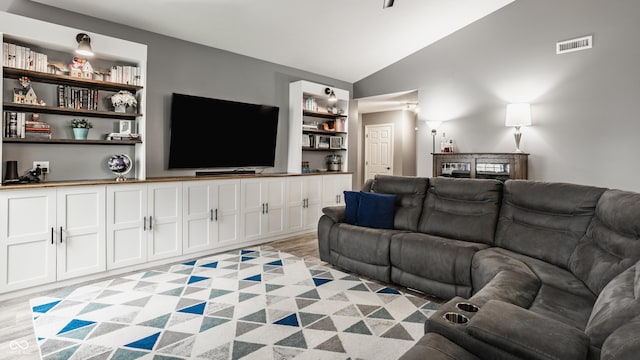 living room with vaulted ceiling and light wood-style flooring
