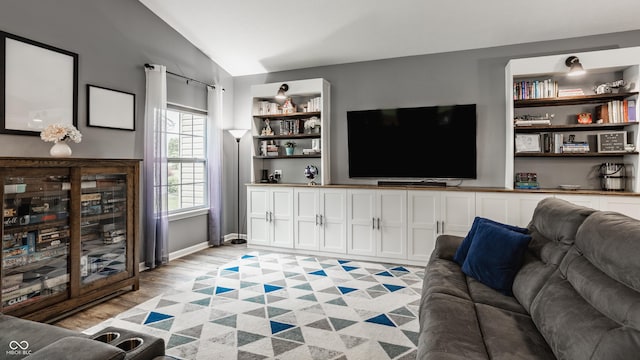 living area featuring vaulted ceiling and light wood finished floors