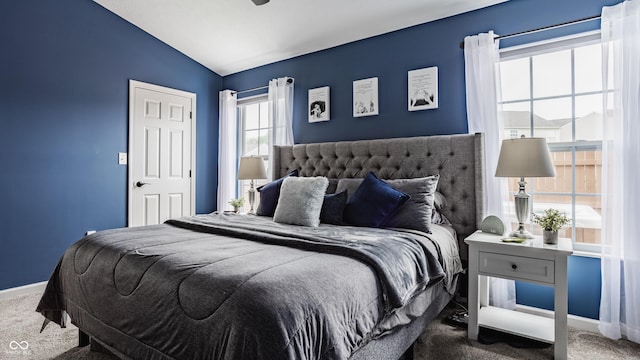 carpeted bedroom featuring lofted ceiling and baseboards