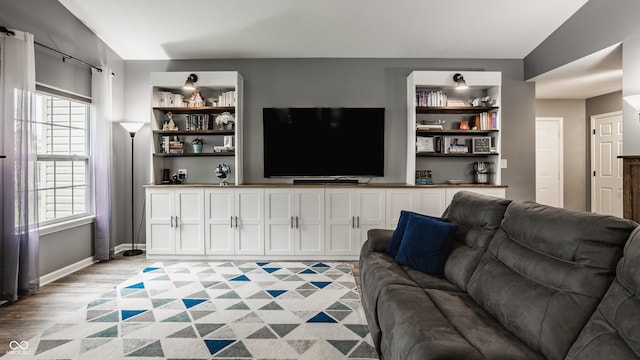 living room featuring built in features and light wood-style flooring