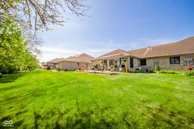 188 Bay Ridge Dr, Pendleton, IN 46064 - rear view of house featuring a patio, a lawn, and brick siding