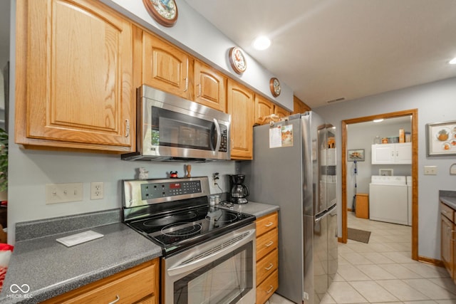 188 Bay Ridge Dr, Pendleton, IN 46064 - kitchen featuring appliances with stainless steel finishes, light tile patterned floors, dark countertops, recessed lighting, and washer and dryer