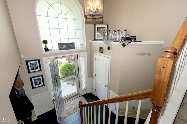 11727 Wedgeport Ln, Fishers, IN 46037 - foyer entrance featuring a chandelier, stairway, a high ceiling, a wainscoted wall, and a decorative wall