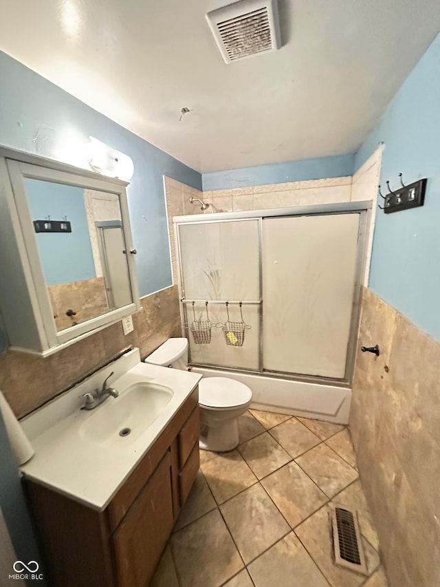 834 N Temple Ave, Indianapolis, IN 46201 - bathroom featuring tile walls, toilet, vanity, tile patterned flooring, and a wainscoted wall