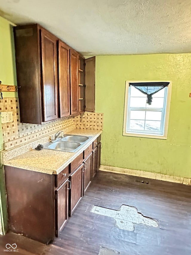 834 N Temple Ave, Indianapolis, IN 46201 - kitchen with a sink, light countertops, dark wood-style flooring, a textured ceiling, and decorative backsplash