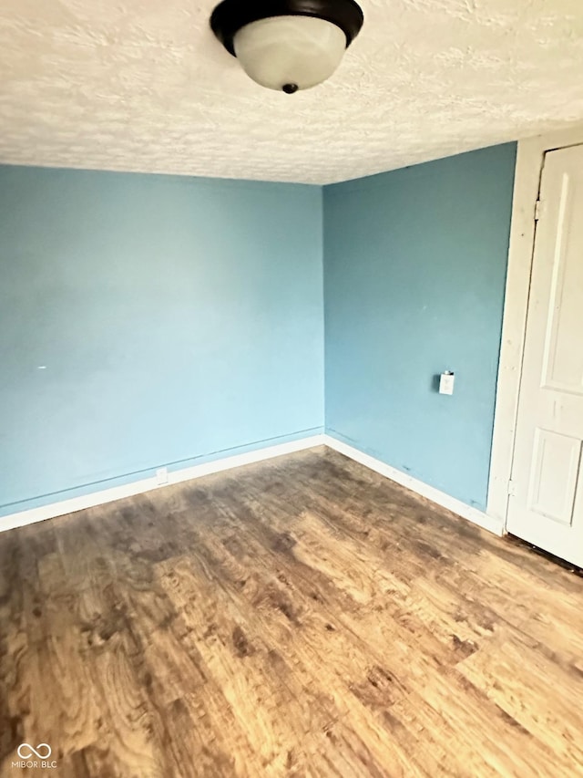 834 N Temple Ave, Indianapolis, IN 46201 - empty room with wood finished floors, baseboards, and a textured ceiling
