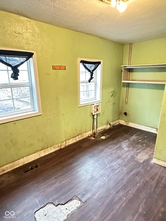 834 N Temple Ave, Indianapolis, IN 46201 - laundry area with plenty of natural light, dark wood-style flooring, a textured ceiling, and baseboards