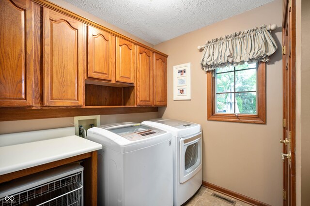 6575 Robin Hood Dr, Indianapolis, IN 46227 - washroom with cabinet space, washer and dryer, a textured ceiling, and baseboards