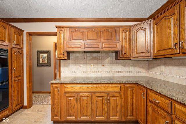 6575 Robin Hood Dr, Indianapolis, IN 46227 - kitchen with backsplash, light stone countertops, black appliances, brown cabinetry, and a textured ceiling